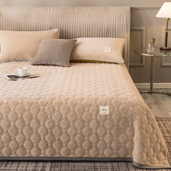 Couvre-lit matelassé beige à surpiqûres ondulées sur un lit double